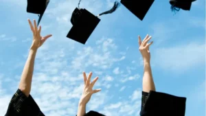 Ręce na tle nieba rzucające czapki arbiturientów